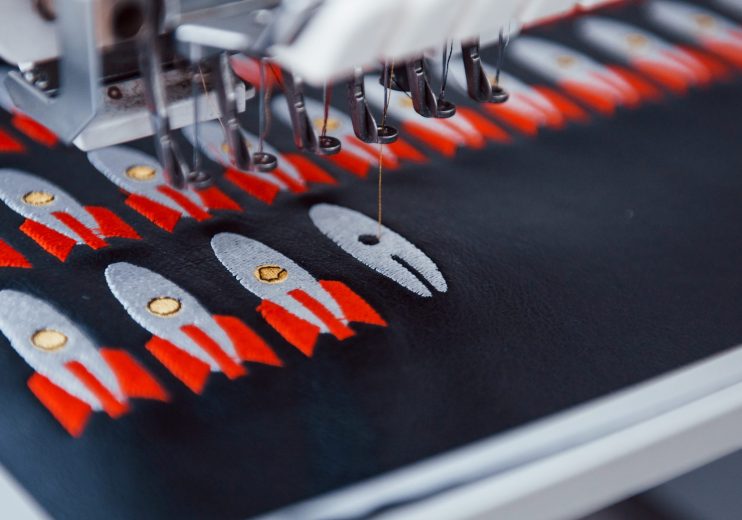 Making rocket pictures. Close up view of white automatic sewing machine at factory in action.